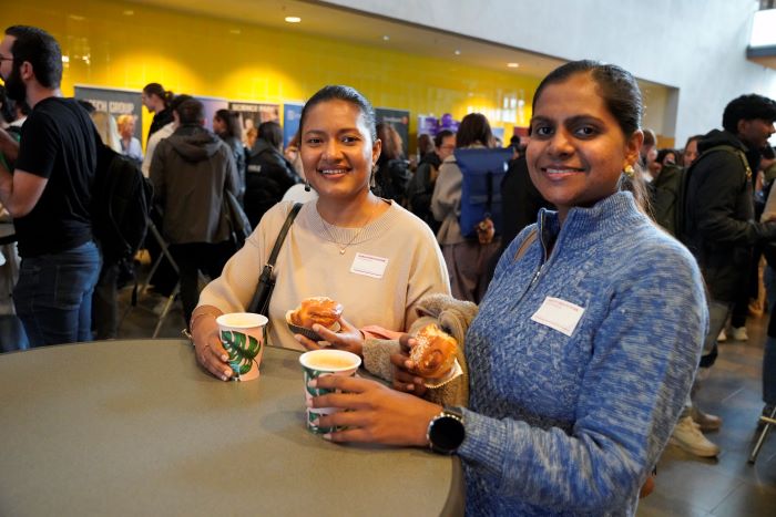 Två tjejer dricker kaffe vid bord