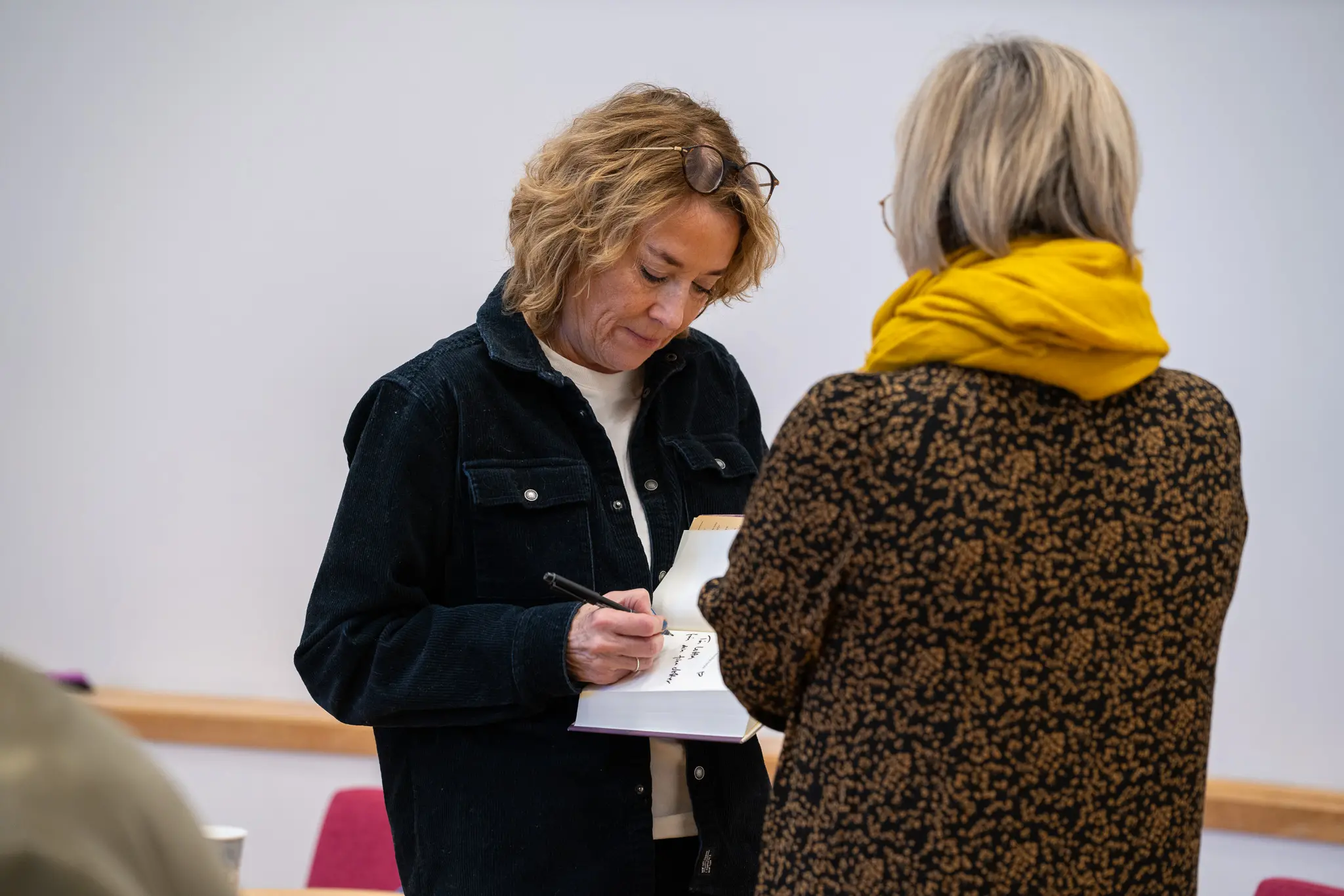 Mian Lodalen signerar en av gästernas böcker.