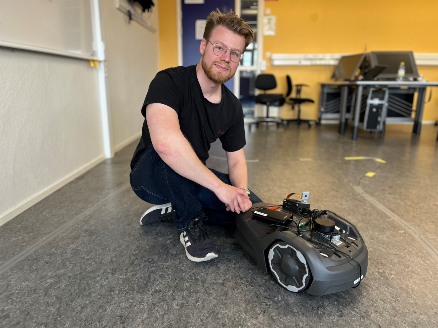 Student at the School of Engineering with a Husqvarna Automower.